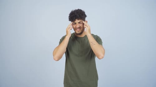 Young Adult Rubs Temples in Discomfort