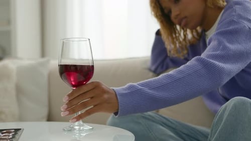 Woman Sitting near Wine Glass on Couch