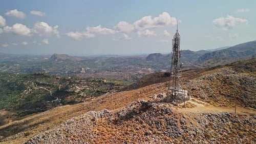 Communication tower stands on a mountain overlooking a vast landscape