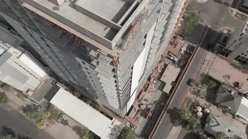 Imágenes Zumbido giratorias de un hotel en construcción, toma aérea en ángulo descendente