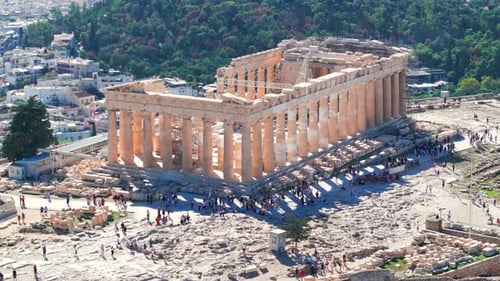 Tight circling aerial shot of the Parthenon surrounded by tourists