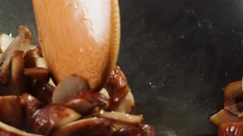 Chef Cooking Mushrooms on Wok Frying Pan Close Up Champignons Mushroom with Salt in Pan Restaurant