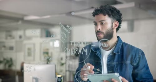 Young Adult Writes on Glass Board in Workplace