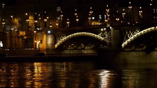 Budapest city (Hungary capital) center view with Margit Bridge and Danube river at night, light refl