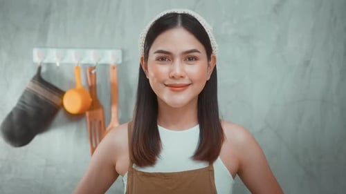 Smiling Young Woman in Kitchen Wearing Apron