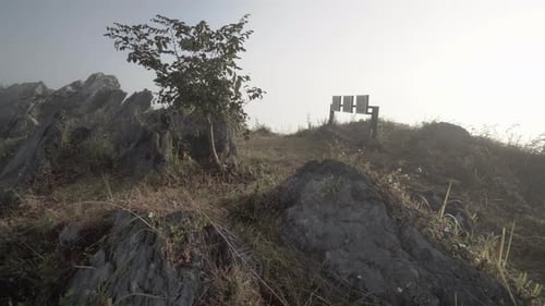 4K panning to the left from the top of a very rocky mountain with low rolling clouds and fog on a ve