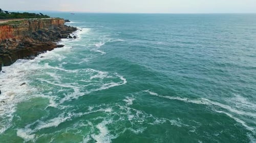 Aerial View Beautiful Rocky Shore Overcast Weather. Deep Blue Ocean Breaking On