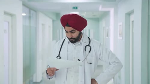 Doctor Reading Patient Notes in Hospital Hallway