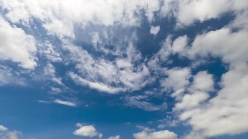 Ethereal white fluffy clouds moving by the sky. Sunny summer day sky timelapse. Low angle view.