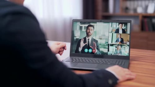 Rear view asian businessman holds a business meeting looking at monitor laptop screen remote,