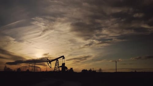 Oil pump and oil refining factory at sunset