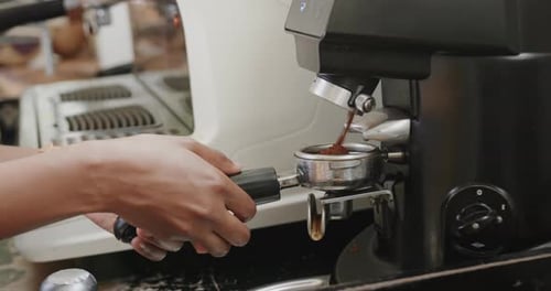 Close up of african american female barista preparing coffee at coffee shop, slow motion