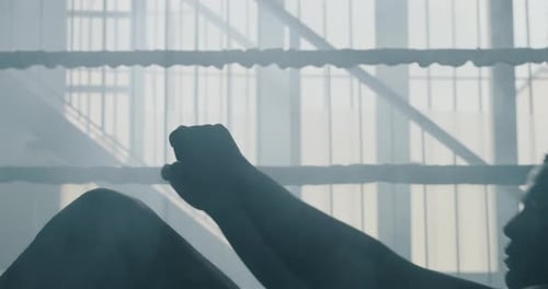Silhouette of Man Doing Sit-ups in Boxing Ring