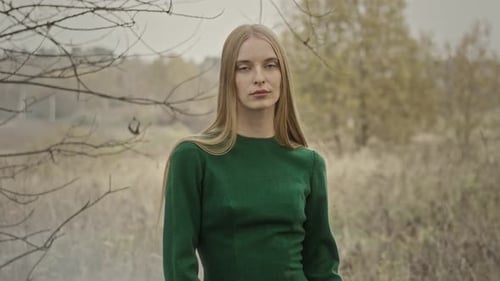 Woman posing wearing green dress in autumn nature