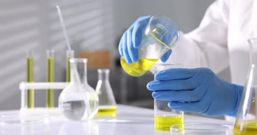 Scientifique vérifiant la qualité de l'huile moteur à une table en laboratoire, gros plan