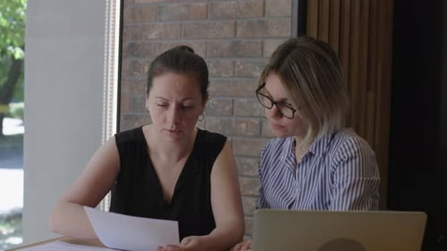 Two Businesswomen Sit Discussion Over Financial Report Commitment to Success Analyze of Financial