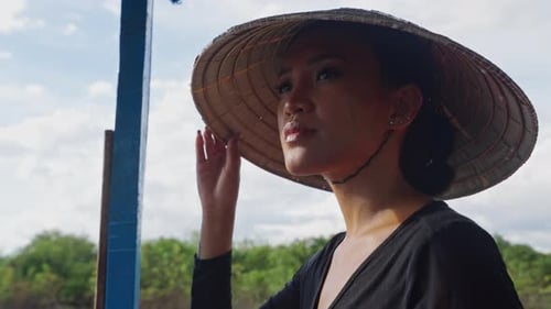 Woman Wearing Conical Hat on a Boat