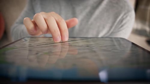 Adult Uses Tablet to Zoom in on Map