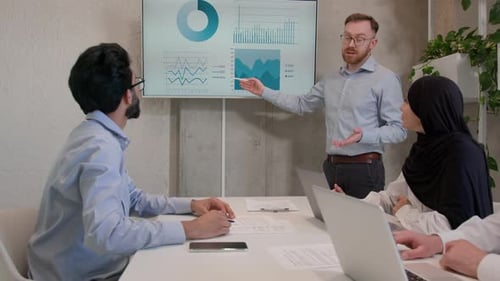 Team Leader Explain Business Project to Colleagues in Office Boardroom Show Presentation Graphs