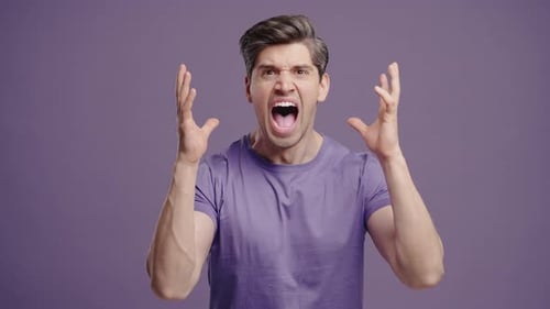 Un homme stressé et en colère crie à un gars sous le choc d'une expression faciale violette paniquée