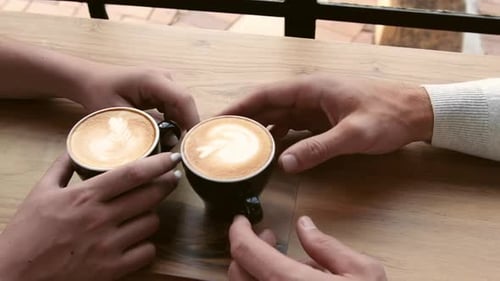 Couple Holding Coffee Cups with Latte Art Coffee. Steadicam