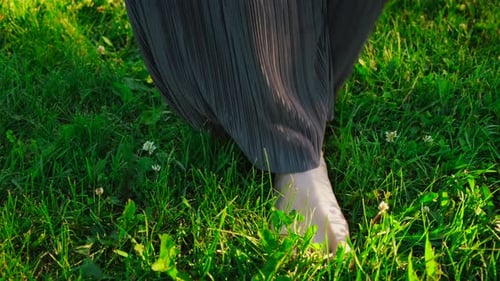 Primer plano de las piernas de las mujeres sobre hierba verde. Concepto. Hermosos pies de mujer