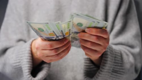 Hands counting United States one hundred dollar bills