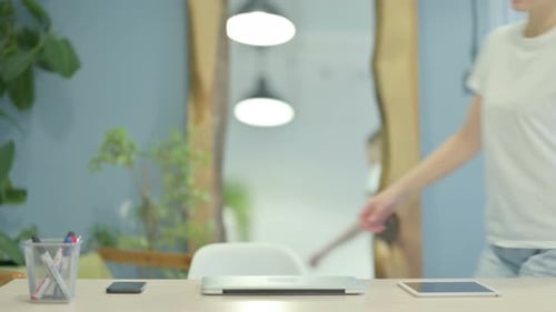 Young Adult Opens Laptop Computer at Desk