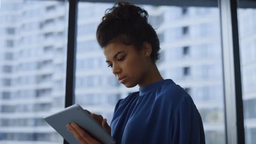 African Businesswoman Working on Digital Tablet in Office. Portrait of Focused Business