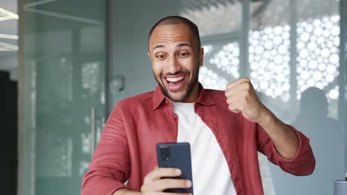 Man Looks at Phone and Reacts Positively