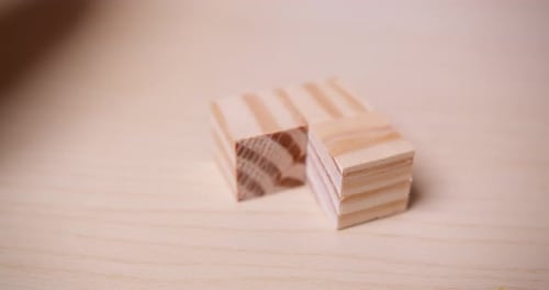 La main déplace des blocs de bois pour créer des carrés pour réussir, composer pour apprendre à résoudre et à réfléchir l