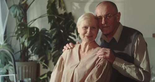 Smiling Senior Couple Embrace Warmly in Their Home