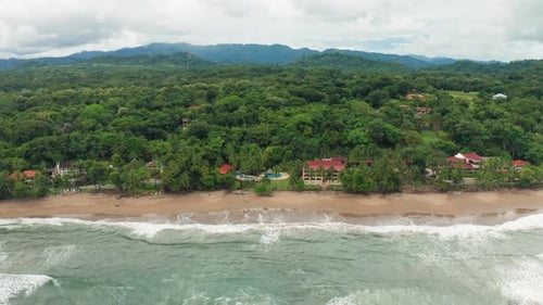4K Aerial Drone shot of Tambor Empty Beach with Costal Resorts in Costa Rica. Dramatic Weather and W
