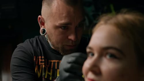 Piercing studio interior - piercing master makes a piercing to a girl, ear piercing