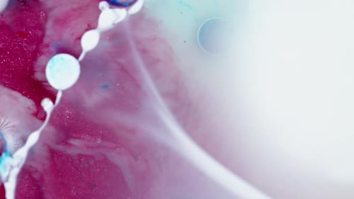 Abstract swirling mix of blue and magenta inks diffusing in water, creating an ethereal fluid art sc