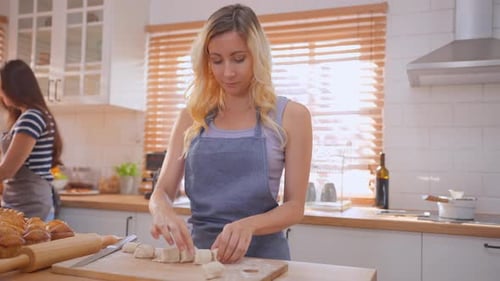 Caucasian young woman baking bakery with friend in kitchen at home.