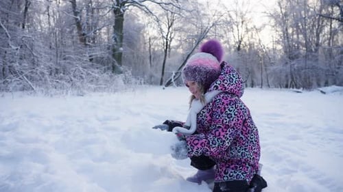 Kinder werfen den Schnee, freuen sich und spielen in einem verschneiten Winterwald