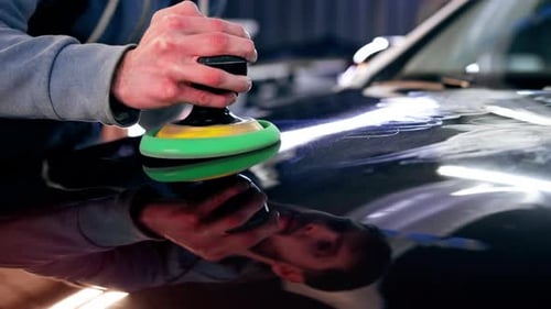 Closeup of the Hands of a Car Mechanic at a Service Station Doing the Final Polishing to Shine