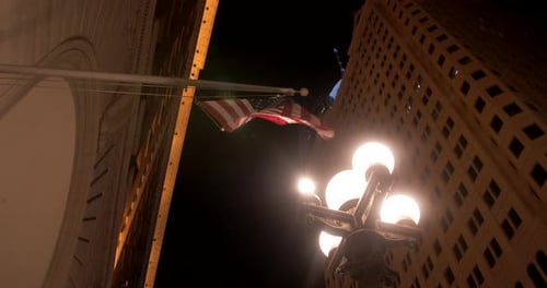 Us flag hanging on a building next to a vintage a street lamp and moving. Downtown Los Angeles by ni