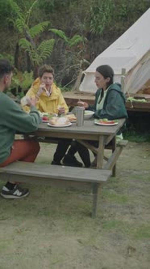 Friends Eating Together at Forest Campsite