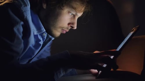 4k video footage of a young businessman using his digital tablet at night at home