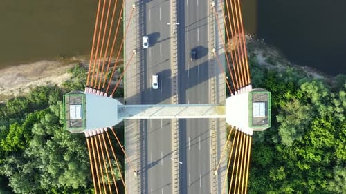 Car moving on modern cable stayed bridge over sea in developed city aerial view