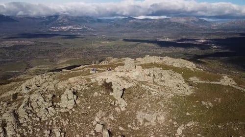 Drone footage of hikers on rocky mountain peak