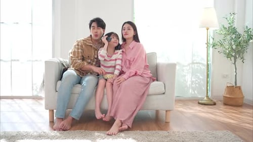 Happy Family Watching TV Together on Couch