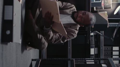 Detective Reviewing Files in a Dimly Lit Office