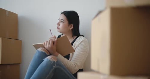 Woman Planning Move Surrounded by Boxes
