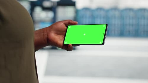 Closeup View of Engineer Using App on Mockup Phone to Do Server Room Checkup