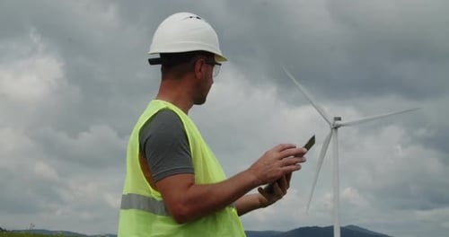 Techniker, Ingenieur, der an einer Windkraftanlage arbeitet und einen Laptop verwendet, Arbeiter oder Bediener überprüft den Wind