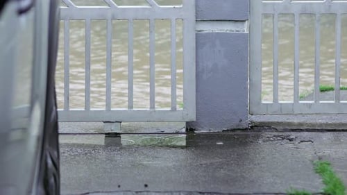 Flooded Road and Sidewalk During Rain in Suburban Area