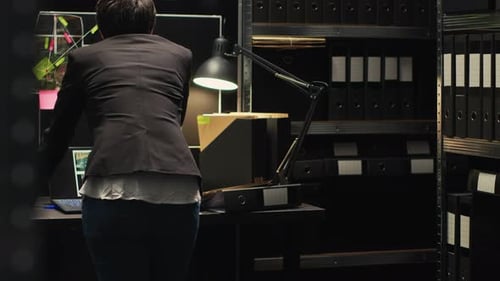 Adult Working in Darkened Urban Office at Desk